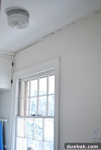 How to Permanently Repair Wall Cracks 3 Close-up of a prominent crack in the laundry room ceiling