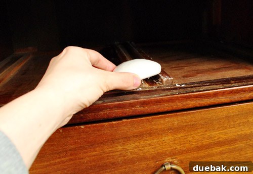 Soap being applied to the interior drawer tracks of the dresser