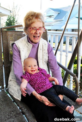 Clara with her great-grandmother, both dressed in shades of purple, sharing a warm embrace.
