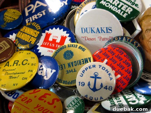 A collection of vintage political campaign buttons, including many for Carter/Mondale.