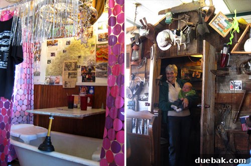 Inside Hillbilly Hot Dogs, showing a themed seating area with a person and baby in an 'outhouse' booth.