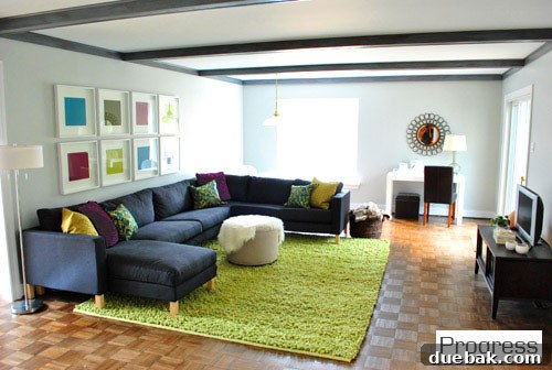 Transformed living room with newly painted walls, trim, and beams, new rug and art