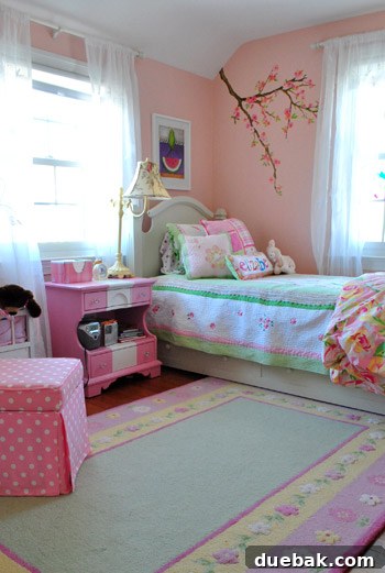 Daughter's bedroom with a charming cherry branch wall mural and a DIY striped nightstand