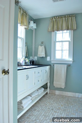 Luxurious master bathroom with a spacious black honed granite vanity and elegant fixtures