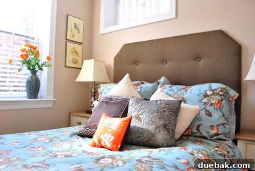 Cozy basement guest room featuring a DIY headboard and comfortable bedding