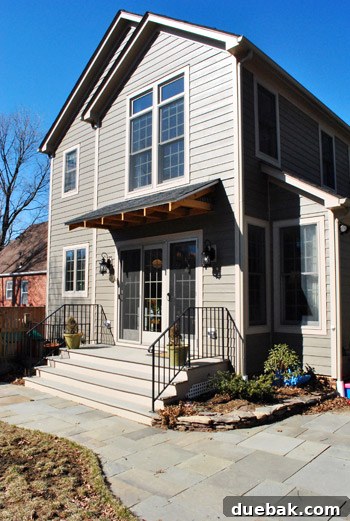 Expansive back patio with wide steps leading to a green lawn, showcasing the home's 2009 addition