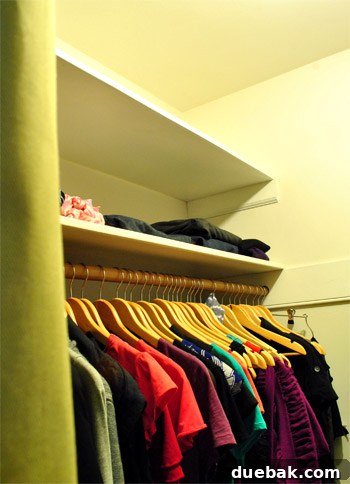 Empty top shelf and neatly organized items on lower shelf in a clean closet