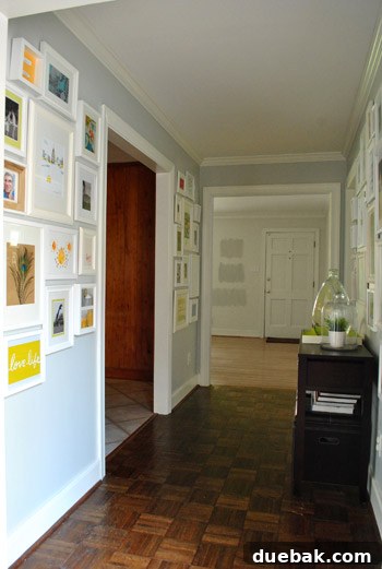 Hallway gallery wall filled with diverse art and personal items