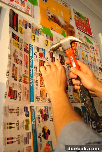 Hammering a nail through a marked newspaper template