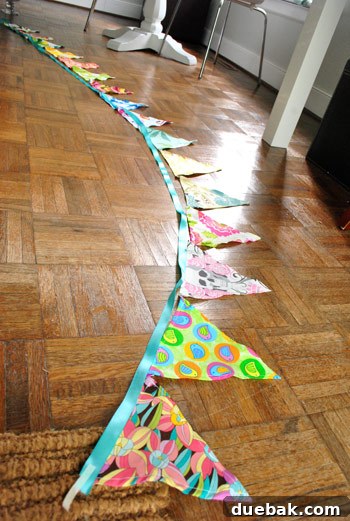 Finished fabric flag banner arranged on a blue ribbon.
