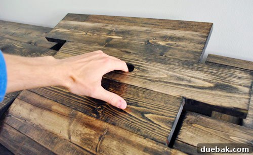 Close-up of the oblong finger hole drilled into the hidden compartment 'puzzle piece' for easy removal.