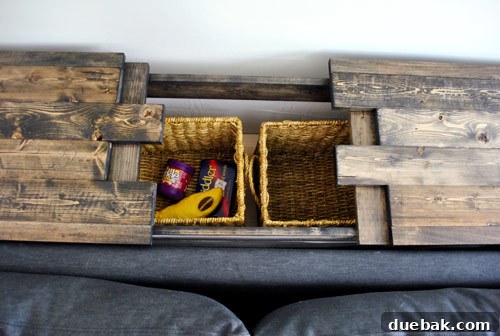 The hidden compartment open, revealing two storage baskets inside and clearly showing the staggered board lip design.
