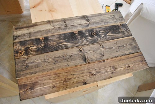 Distressed and stained wood boards arranged, showcasing varying tones and textures, ready for console tabletop assembly.