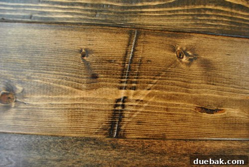 A prominent long dent added to new wood, beautifully defined after staining with a medium wood stain, adding significant character.
