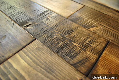 Demonstration of the distressed effect created on new wood boards, successfully transforming them to look old and genuinely reclaimed.