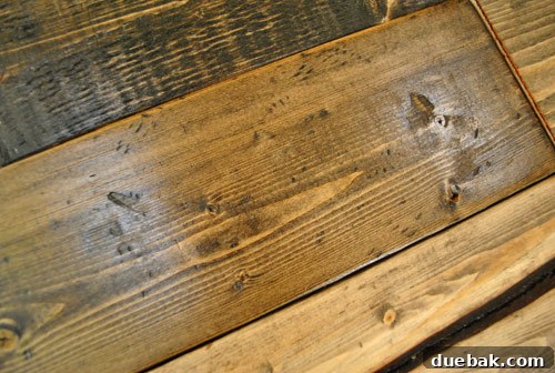 Distressed wood showing subtle dings created by hitting with a bag of screws, beautifully accentuated after applying a dark wood stain.