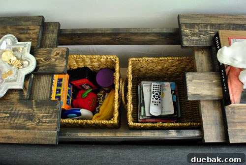 Open console compartment revealing two woven baskets, one for board games, one for books.