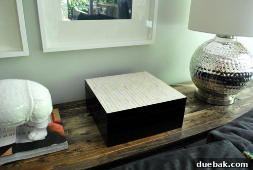 Close-up of a stylish black lacquered box with a capiz shell lid on the console table.