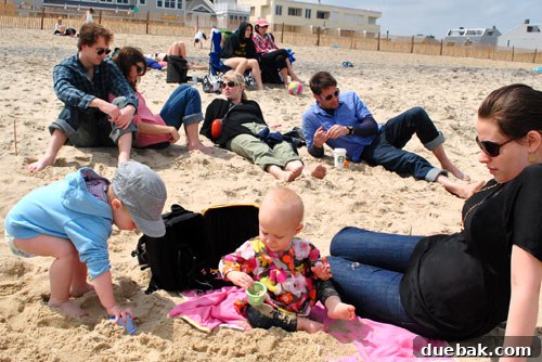 Easter Steals 17 Clara sitting on the sand, intently exploring its texture with her fingers