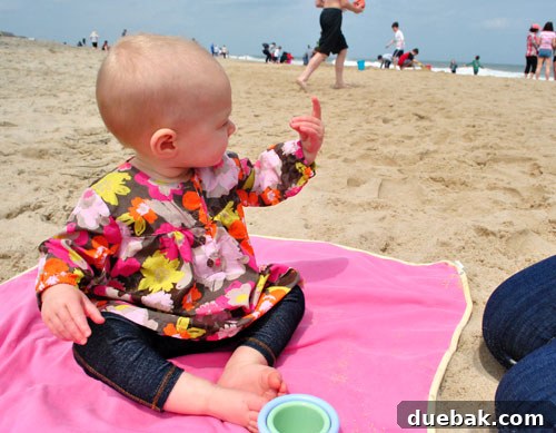 Easter Steals 18 Clara holding sand, observing it intently before a playful toss