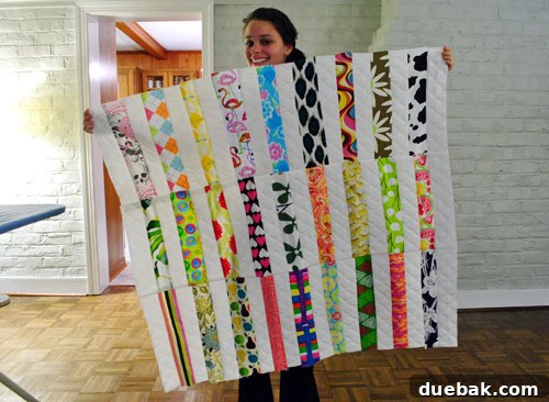 Proud quilter smiling with a partially assembled quilt