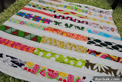 Adorable shot of the baby quilt draped on a bed