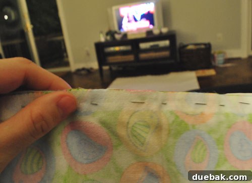 Close-up of colorful fabric strips being pinned together for a quilt