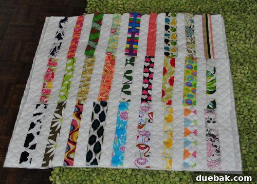 Three long sewn fabric rows laid out to form a quilt square