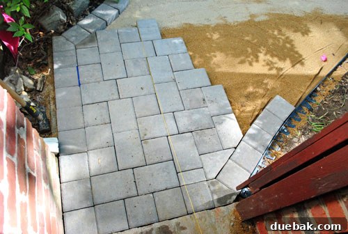 First section of cobblestone pavers laid down at the patio entrance