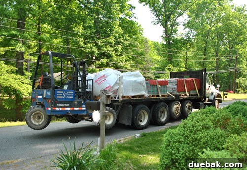 Flatbed truck delivering heavy patio materials like gravel, sand, and pavers