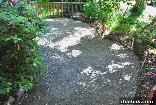 Gravel base spread out, showing nylon strings used for leveling and slope