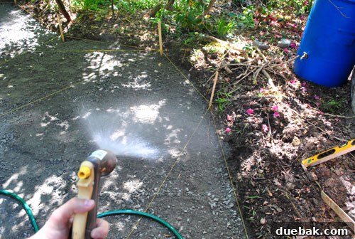 Lightly misting the gravel base before tamping it down for the patio