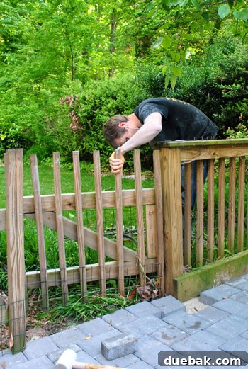 DIY Paver Patio: Transform Your Backyard 10 Man adjusting a gate next to the patio