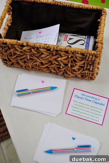 A basket labeled 'Clara's Time Capsule' with note cards and pens for guests to contribute.
