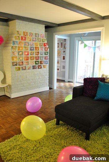 Paper pendant hanging above hallway sliders and 52 weekly photos of Clara displayed on the fireplace.