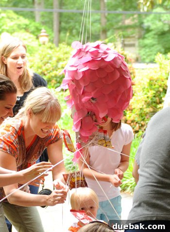 A homemade pull-string piñata, decorated with tissue paper scales.