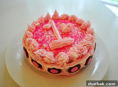 A small, child-sized smash cake with a single candle for a one-year-old.