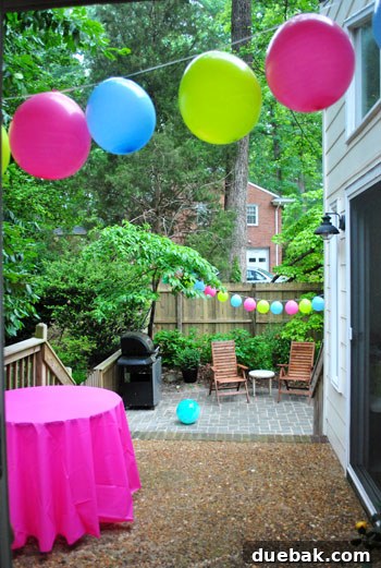 Balloons strung on a patio, ready for a party despite the misting rain.