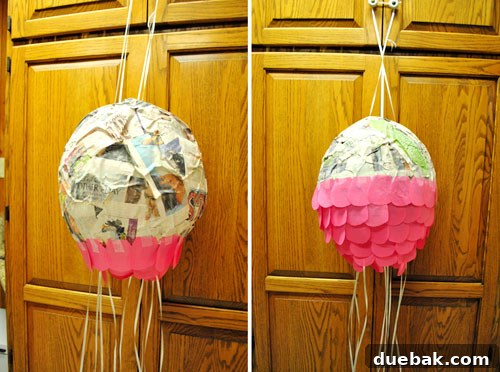 Craft Your Own Pull String Piñata 18 Applying pink tissue paper scales to the piñata