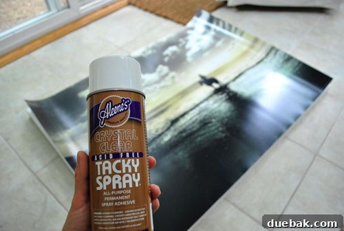 Securely Mounting Large Prints to Canvas Using Acrylic Medium 2 Applying spray adhesive to the back of a large print for canvas mounting