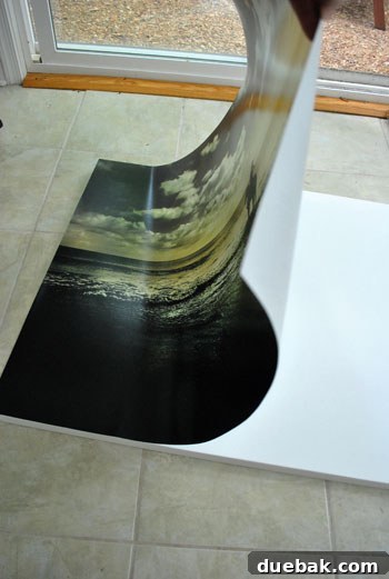 Securely Mounting Large Prints to Canvas Using Acrylic Medium 3 Smoothing out a large print on canvas with a credit card after spray adhesive application