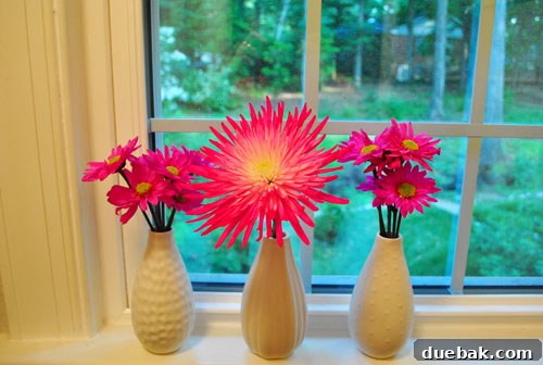 Compact floral display of rescued pink blooms in a unique patterned vase, enhancing bathroom decor