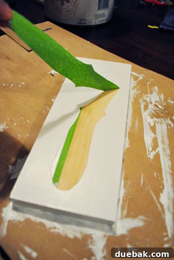 Peeling off painter's tape to reveal the stenciled number seven