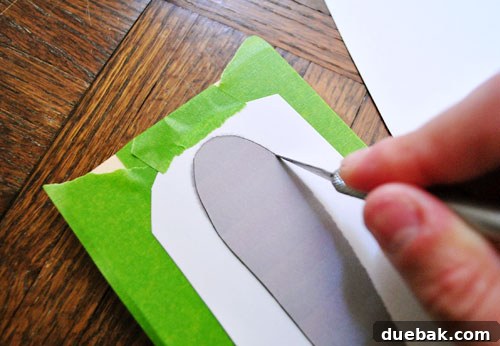 Using an exacto knife to cut the number seven stencil into the tape