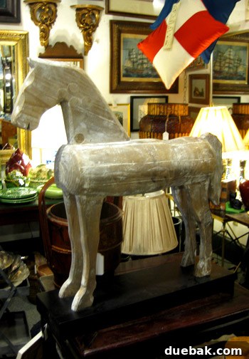 A large, beautifully crafted wooden horse statue displayed for sale in the Antique Mall, a striking vintage piece.