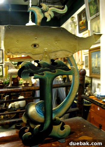 A unique tin whale decorative piece with interactive features, such as a moving mouth and eye, found in the Antique Mall.
