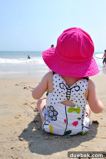 A candid photo of Clara, a young child, enjoying her time on the beach during a family vacation.