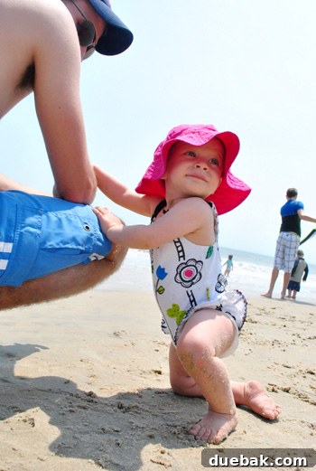 Clara playing in the sand on the beach, captured in a sweet moment of childhood fun.