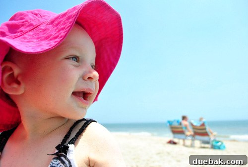 Clara enjoying the beach, with family in the background, making precious holiday memories.