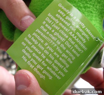 A small green doll named Groody, with a humorous and relatable tag describing his stressed-out personality.